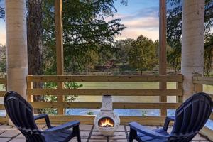 2 stoelen en een vuurplaats op een patio bij Luxury River Front Twin House 8beds Sleeps 22 in New Braunfels