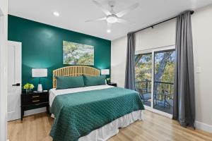 een slaapkamer met een bed en een groene muur bij Luxury River Front Twin House 8beds Sleeps 22 in New Braunfels