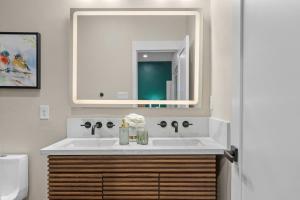 een badkamer met een witte wastafel en een spiegel bij Luxury River Front Twin House 8beds Sleeps 22 in New Braunfels +275 foto's