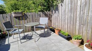 a patio with a table and chairs and a fence at Fyrish View in Dingwall +23 photos
