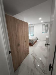 a bedroom with a bed and a wooden cabinet at Airbhouse Prívate Rooms & Apartments Triana in Seville