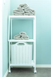 a white shelf filled with towels in a room at RD House in Katsuyama
