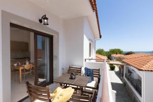 a balcony with a table and chairs on a building at Pelago White in Skala Potamias