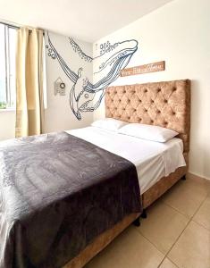 アルメニアにあるLoft Blue con parqueaderoのベッドルーム1室(クジラの看板が壁に貼られたベッド1台付)