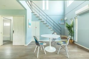 a room with a table and chairs and stairs at RD House in Katsuyama
