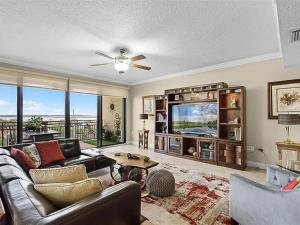 a living room with a couch and a tv at Spacious Lakefront Condo in Kissimmee in Kissimmee