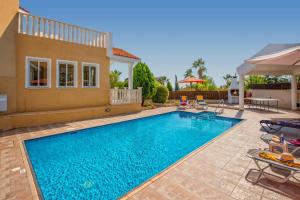 a swimming pool in front of a house at Villa Gardenia by Villa Plus in Peyia