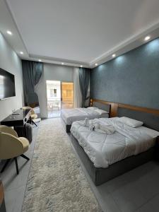 a room with three beds and a table and chairs at Luxury serviced apartments in Hurghada