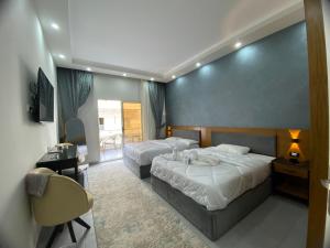 a hotel room with two beds and a desk at Luxury serviced apartments in Hurghada +21 photos