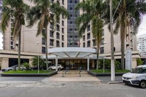 a parking lot in front of a building with palm trees at Ellegance Luxo Aeroporto Congonhas - S608 in Sao Paulo