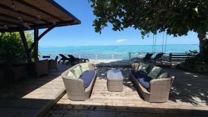 a patio with chairs and a table and the ocean at Villa Miti Vai by ENJOY VILLAS in Iumaru