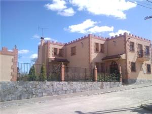 una casa grande con una pared de piedra delante de ella en Fuerte de San Mauricio, en Palazuelo de Vedija