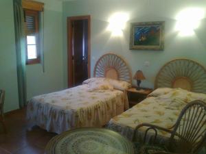 Un dormitorio con dos camas y una mesa y sillas. en Fuerte de San Mauricio, en Palazuelo de Vedija