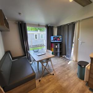 Televízia a/alebo spoločenská miestnosť v ubytovaní MOBIL-HOME CONFORTABLE ET BIEN EQUIPE AVEC PISCINES ET LA PLAGE A PIED