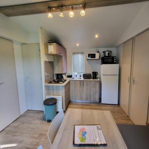 Kuchyňa alebo kuchynka v ubytovaní MOBIL-HOME CONFORTABLE ET BIEN EQUIPE AVEC PISCINES ET LA PLAGE A PIED