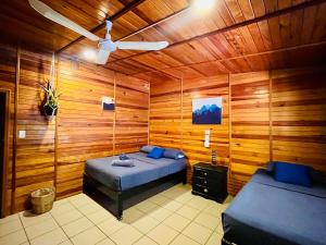 a bedroom with two beds and a ceiling fan at Wasi la Punta 4 Starlink 2min walk to the beach in Brisas de Zicatela