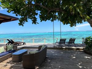 a group of chairs sitting on a porch overlooking the ocean at Villa Miti Vai by ENJOY VILLAS in Iumaru