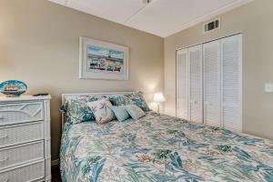 a bedroom with a bed and a dresser at 2 Bed/2 Bath Oceanfront condo sleeps 6. Oceanfront deck and pool. in Fernandina Beach +15 photos