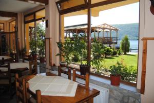 a restaurant with a table and a view of the water at Pension La Ponton in Eşelniţa
