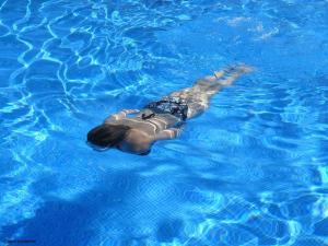 a woman laying on her back in a swimming pool at Silver Apartments - Poznań - by Kramm Apartments in Poznań +36 photos