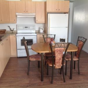 a kitchen with a table and chairs and a refrigerator at Les appartement 4 saisons des iles in Saint-Gédéon