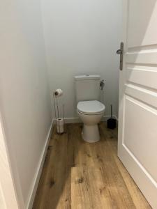 baño con aseo blanco y suelo de madera en Chambre d'hôtes Villa Santina, en Piquecos 1 foto más