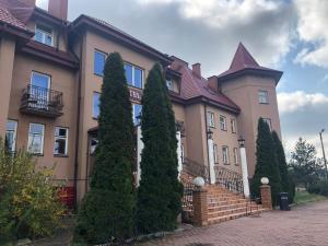 a large house with trees in front of it at Forest Castle in Maurzyze