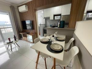 a kitchen and dining room with a table and chairs at Apartamento com Varanda Gourmet e Wi-Fi Rápido - Renove as Energinas Vila Caiçara Praia Grande in Praia Grande