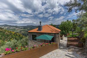 a small building with a green roof with flowers at ALDEIA DA MARGARIDA in Tarouquela