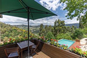 a patio with a table and an umbrella at ALDEIA DA MARGARIDA in Tarouquela