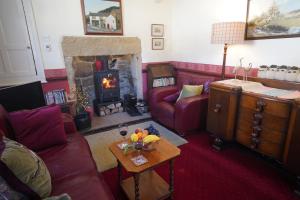 ein Wohnzimmer mit Couch und Kamin in der Unterkunft Traditional 2 Bedroom Cottage in Eyam Hope Valley in Eyam + 23 Fotos