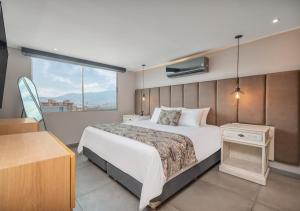 a bedroom with a large bed and a window at Affinity ApartaHotel in Medellín