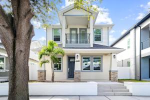 a white house with a tree at Spacious Modern 5-Bedroom House, Close to Downtown Tampa in Tampa