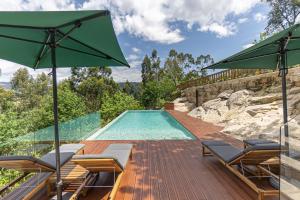 a swimming pool with chairs and a green umbrella at ALDEIA DA MARGARIDA in Tarouquela +54 photos