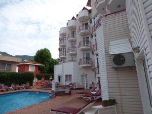 a hotel with a swimming pool next to a building at Avlu 4 in Marmaris