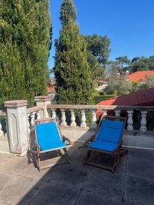 two blue chairs are sitting on a balcony at Maison volets bleus - jusqu'à 9 personnes - 3 chambres - Arcachon Centre in Arcachon