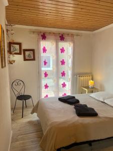 a bedroom with a bed and a window with pink flowers at Maison volets bleus - jusqu'à 9 personnes - 3 chambres - Arcachon Centre in Arcachon