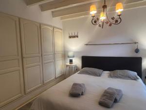 a bedroom with a white bed with two pillows on it at Maison volets bleus - jusqu'à 9 personnes - 3 chambres - Arcachon Centre in Arcachon