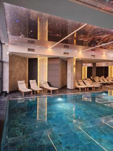 a hotel lobby with a pool and chairs at Marrilux apartments Residence Hill in Kopaonik