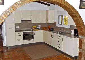 eine Küche mit weißen Schränken und einem Torbogen in der Unterkunft Ferienhaus mit Privatpool für 4 Personen ca 190 m in Sedella, Andalusien Costa del Sol in Sedella