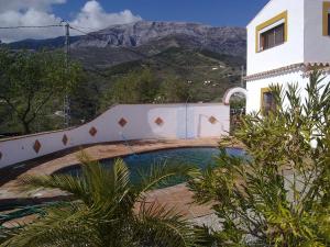 ein Haus mit einem Pool vor einem Berg in der Unterkunft Ferienhaus mit Privatpool für 4 Personen ca 190 m in Sedella, Andalusien Costa del Sol in Sedella + 22 Fotos