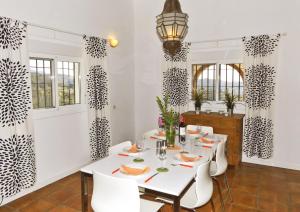 ein Esszimmer mit einem weißen Tisch und weißen Stühlen in der Unterkunft Ferienhaus mit Privatpool für 4 Personen ca 190 m in Sedella, Andalusien Costa del Sol in Sedella