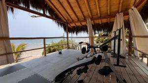 a gym with a bike in a room with the beach at Baja Canoas Hotel in Canoas De Punta Sal