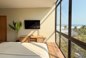 Un dormitorio con una cama y vistas a la playa. en Wave House, en El Zonte
