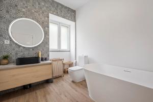 a bathroom with a tub and a sink and a mirror at Villa Pomar, By OP in Senhora do Rosário +25 photos