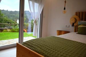 a bedroom with a bed and a large window at Casa de Suelas in Lavradas +11 photos