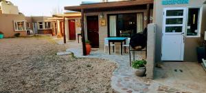 a house with a patio with a table and a door at la posta in Puerto Pirámides