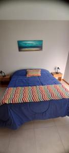 un letto con piumone blu in una camera da letto di la posta a Puerto Pirámides Altre 9 foto