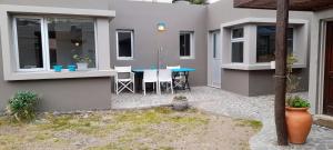 a house with a patio with a blue table at la posta in Puerto Pirámides