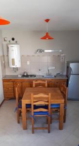 una cucina con un tavolo di legno e un frigorifero di la posta a Puerto Pirámides